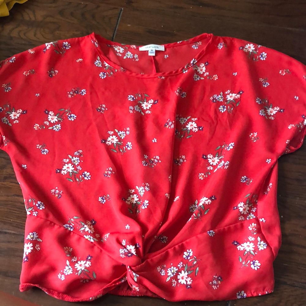 this is a red kids T-shirt it has flowers on it and it’s a medium.
